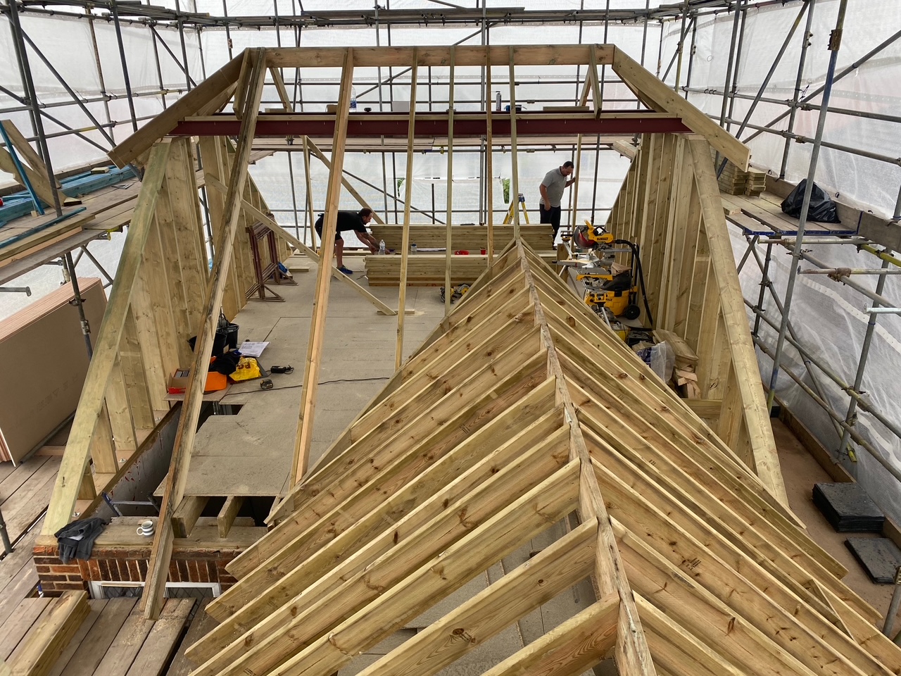 Interior view of a construction site showing wooden framework and scaffolding.